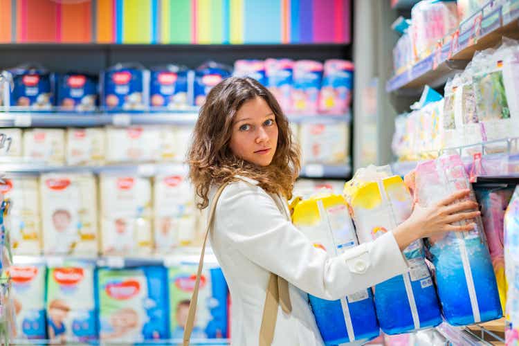 woman mother buys diapers for future use, mother of many children in the supermarket