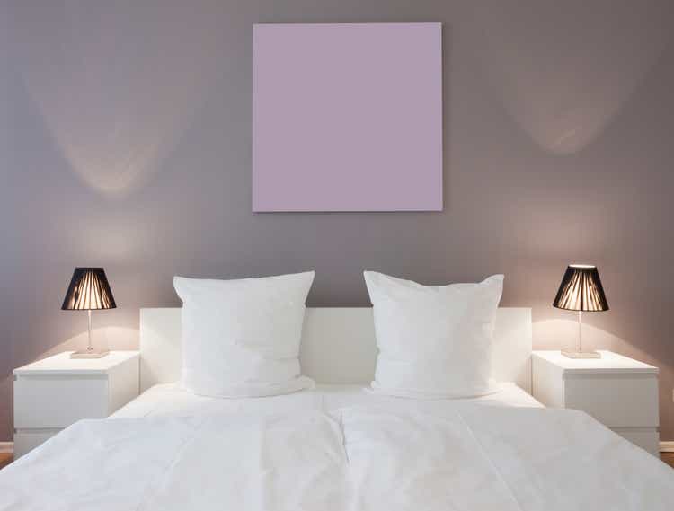 White master bed with white night stands and lights