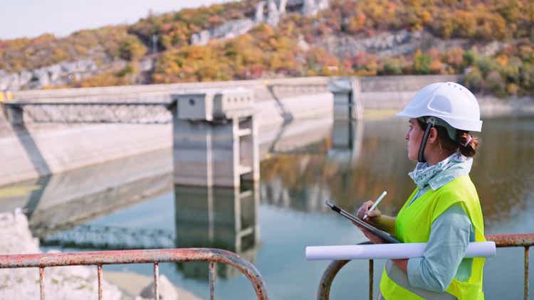 Maintenance female engineer working in hydroelectric power station. Renewable energy systems.