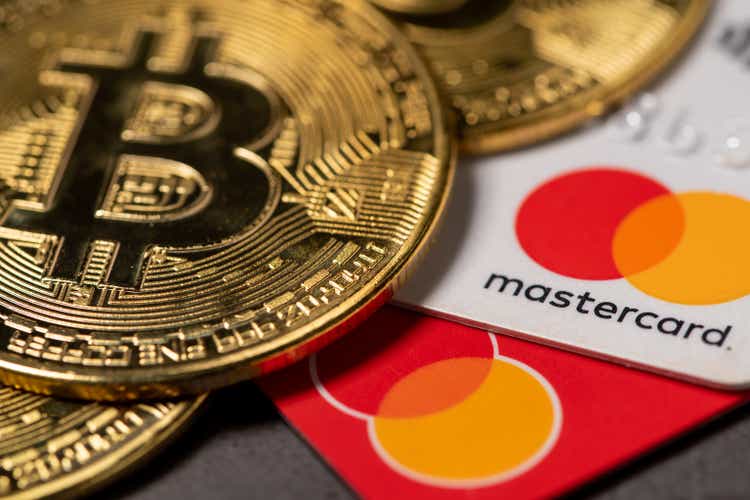 Antalya, Turkey - November 1, 2021: Bitcoin cryptocurrency standing on a MasterCard credit card.