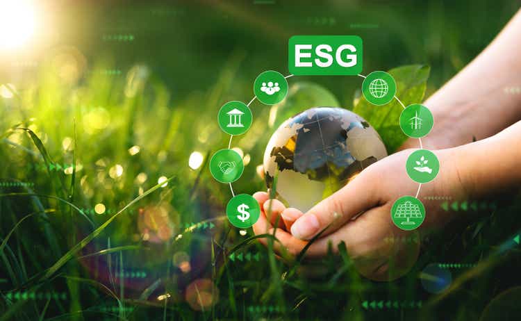 Environment social and governance in sustainable and ethical business. Hands holding crystal globe with ESG icons. Using technology of renewable resource to reduce pollution.