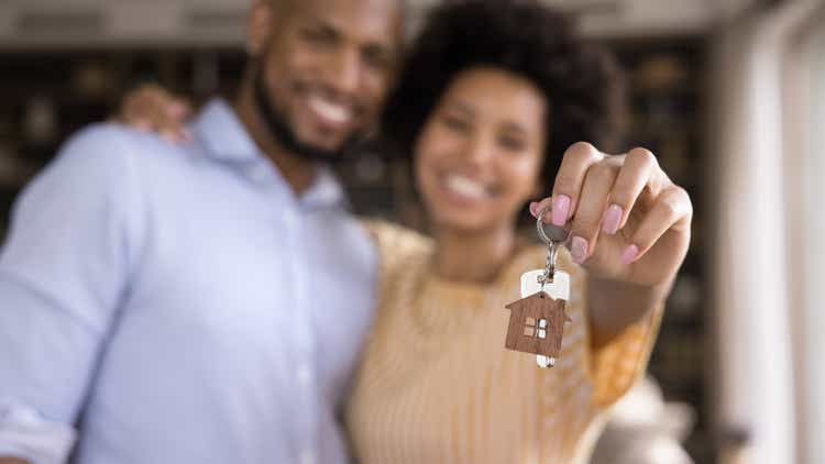 Close up keys in hands of blurred african couple.