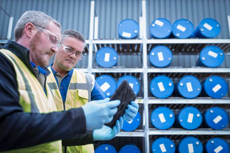 UK, Manchester, Workers using digital tablet in oil blending plant