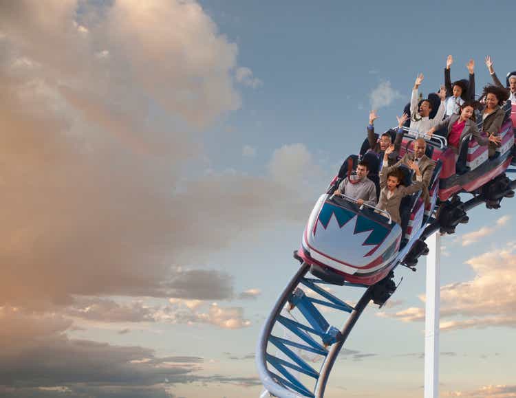 Business people riding roller coaster