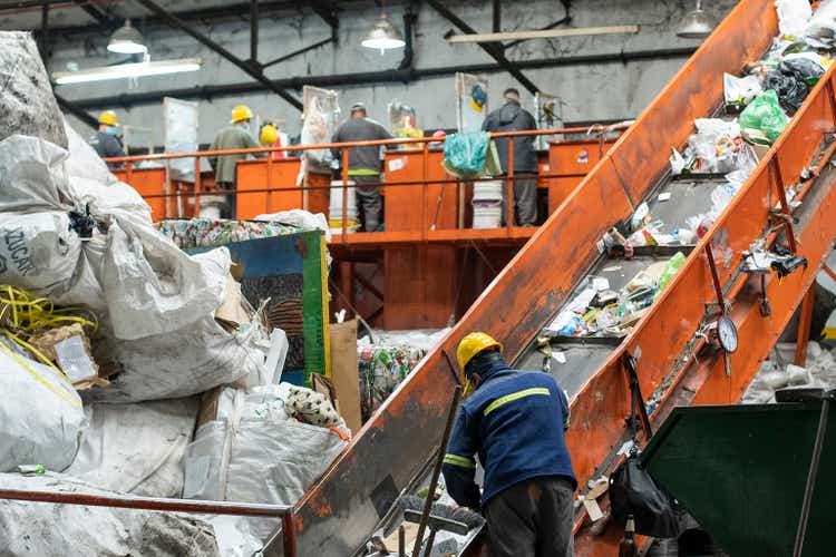 Workers sorting recyclable materials on conveyor belt