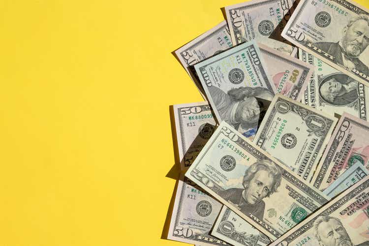 Scattered 100 American Dollars.Economic Crisis dollars money cash on yellow background. Background is banknote of US Dollar.many identical money notes in a mess.Copy space