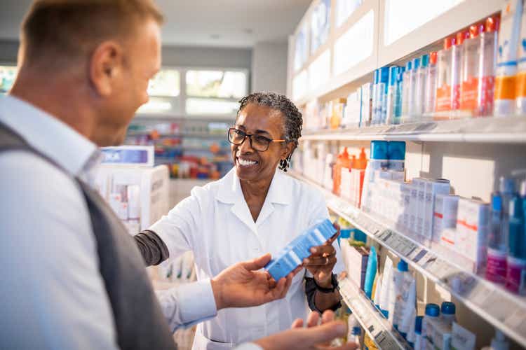 Pharmacist helping a businessman with choosing the right product