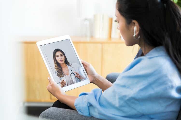 Serious doctor talks with woman during telemedicine appointment
