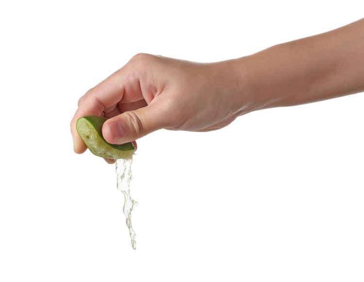 Hand squeeze green lime isolated on white background