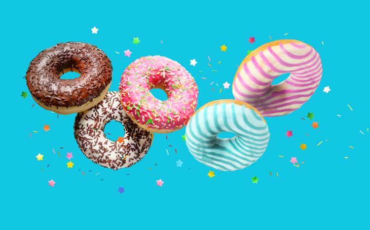 Delicious glazed donuts Falling on turqouise blue background background.