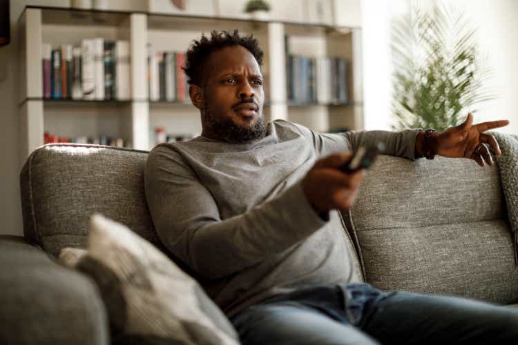 Angry man watching tv at home