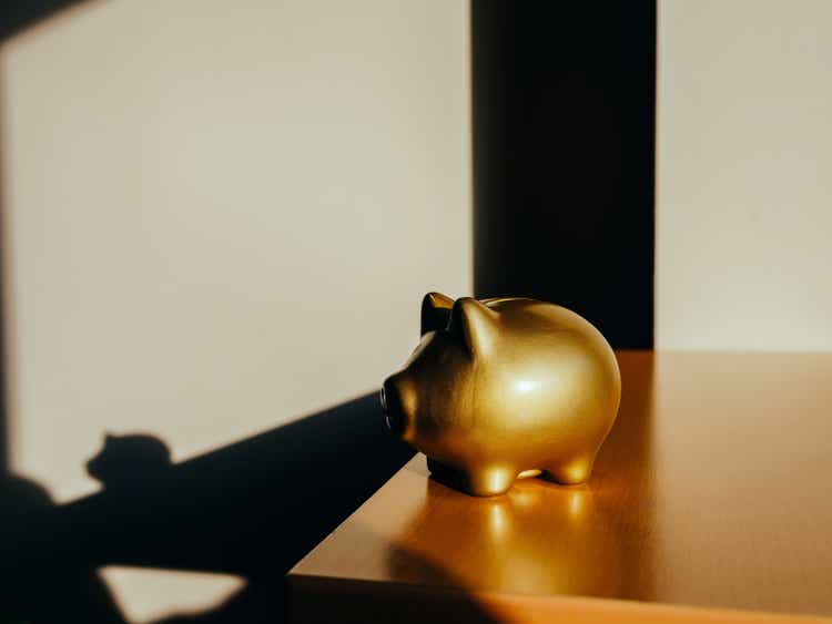 Golden piggy bank in front of white background.