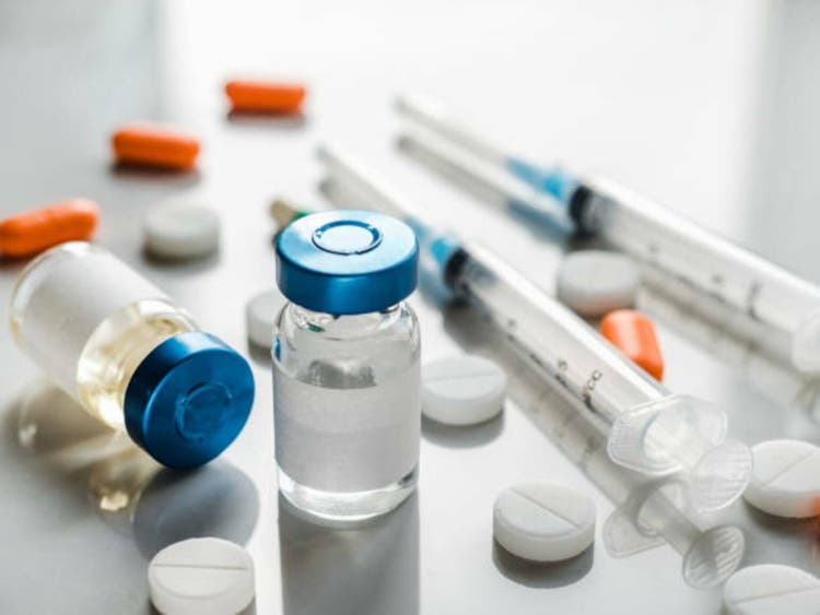 Syringes, injection bottles and tablets lying on the table