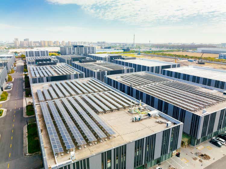 Aerial view of solar panels on factory roof. Blue shiny solar photo voltaic panels system product.