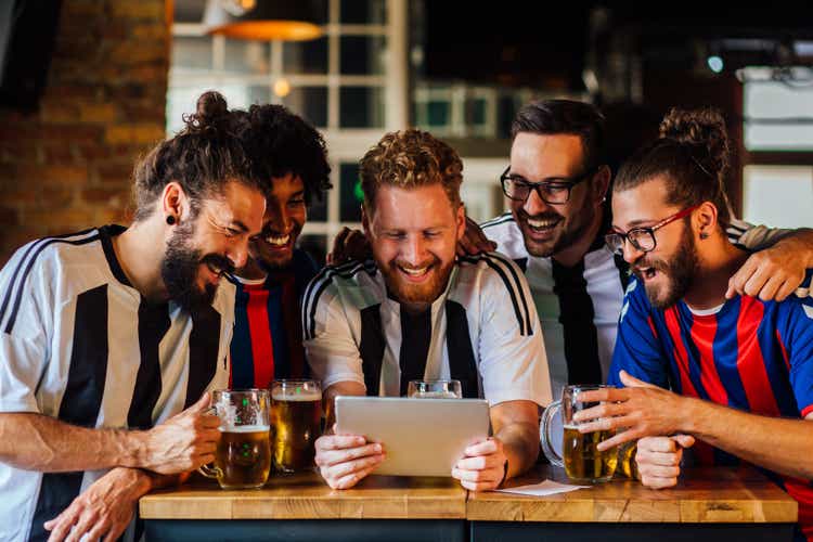 Group of friends watching the football game at the pub