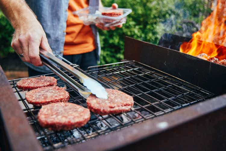 Shot of a man grilling burgers during a barbecue