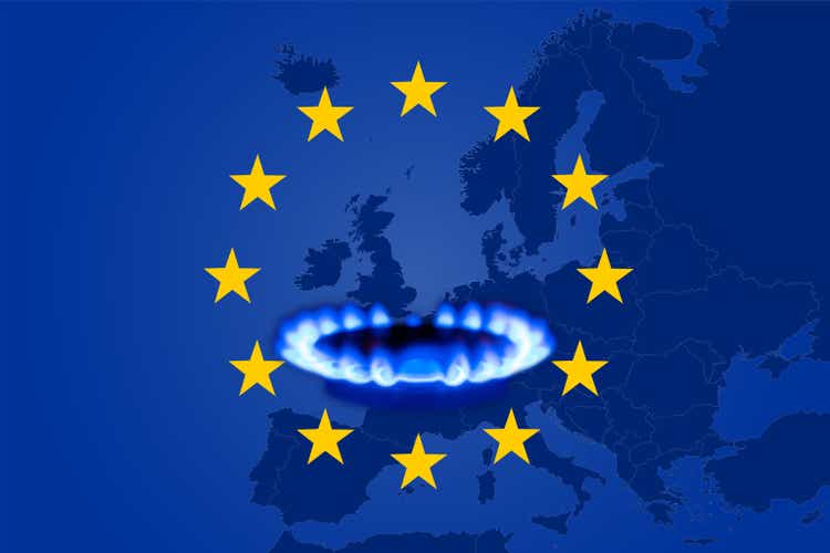 Deficit and gas crisis in Europe. Flag of the European Union with a geographic map and a burning gas stove. Copy space.