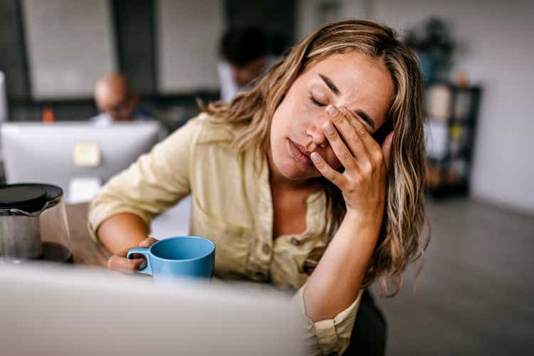 Tired business woman rubbing eyes