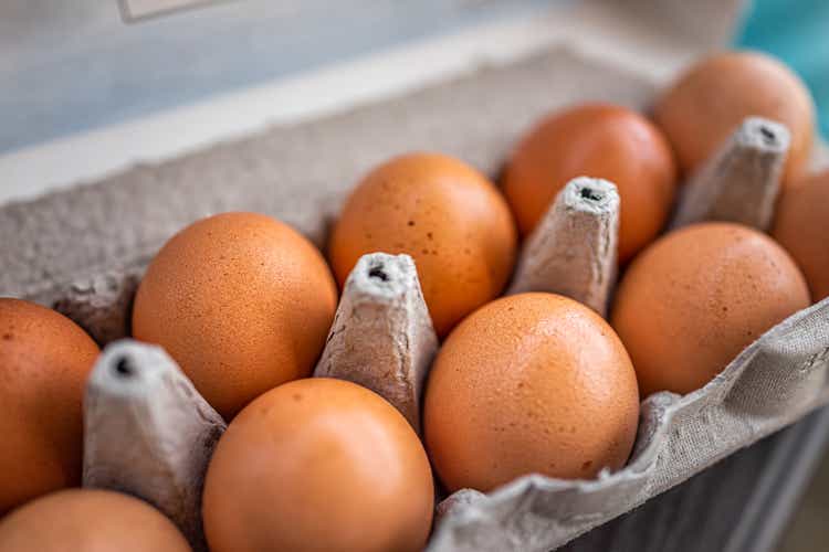 Closeup macro of pasture raised farm fresh dozen brown eggs store bought from farmer in carton box container with speckled eggshells texture