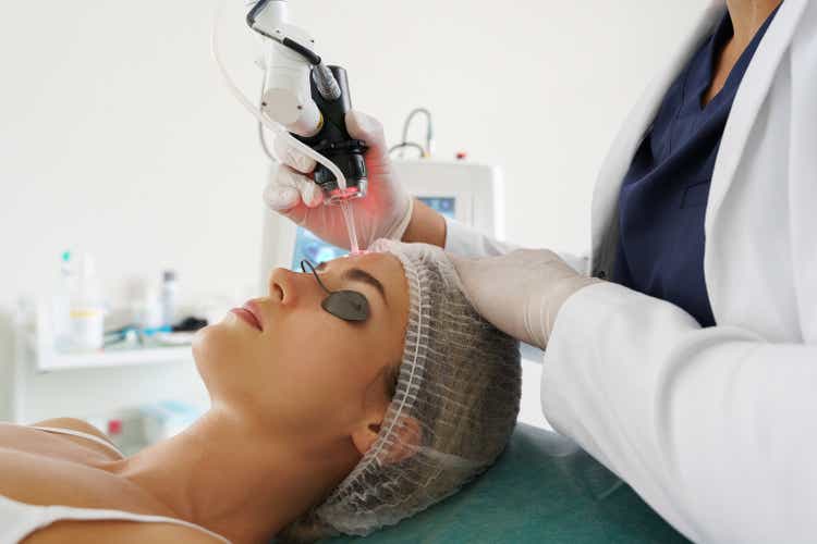 Doctor dermatologist and woman client during laser skin resurfacing treatment