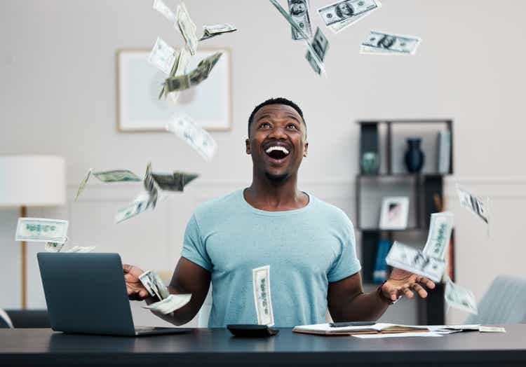 Shot of a young businessman managing his money at home