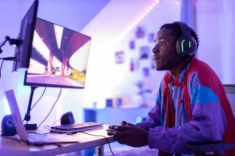 Young male gamer playing at night