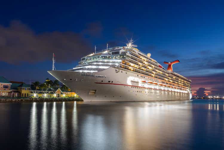 Carnival Liberty cruise ship docked at Prince George Wharf. Blue hour. Gorgeous reflections of the ship"s and port"s lights in the harbour water in the foreground