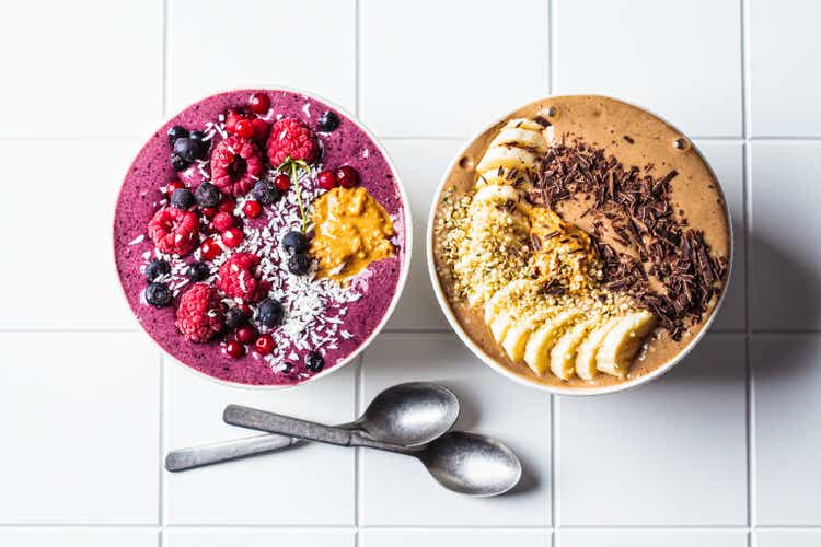 Chocolate and berry smoothie bowls on white background. Raw vegan food concept.