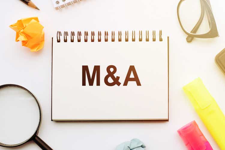 The letters M and S written on notepad. Glasses and magnifier are on white background. M and A short for Mergers and Acquisitions, business concept.
