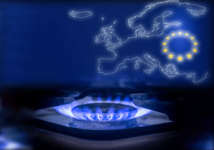 The blue flame of a gas stove in the dark. Gas burner on the background of the map and the flag of the European Union. The concept of gas consumption in Europe
