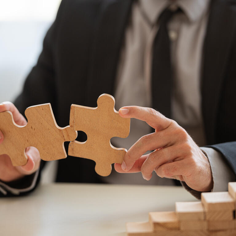 Closeup view of businessman matching two puzzle pieces together