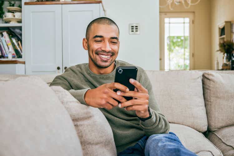 Shot of a young man using his smartphone to send text messages