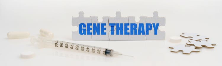 On a white background lie a syringe, pills and puzzles with the inscription - GENE THERAPY