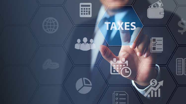 Businessman using innovative virtual touchscreen presses taxes button.with icons state taxes.Data analysis,paperwork,financial research,report.Calculation tax return surrounding.taxes Concept