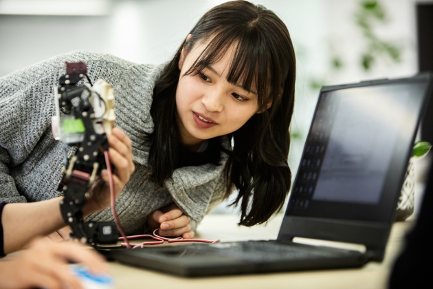 A female employee of a start-up company checks a prototype robot