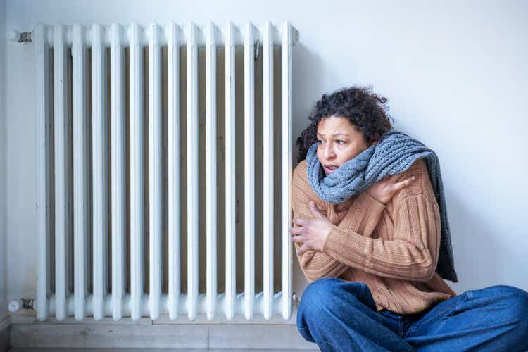 Black woman suffering cold at home because of home heating problem