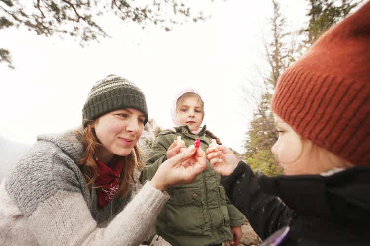 MOther with daughters having fun on trip eating gummy bears