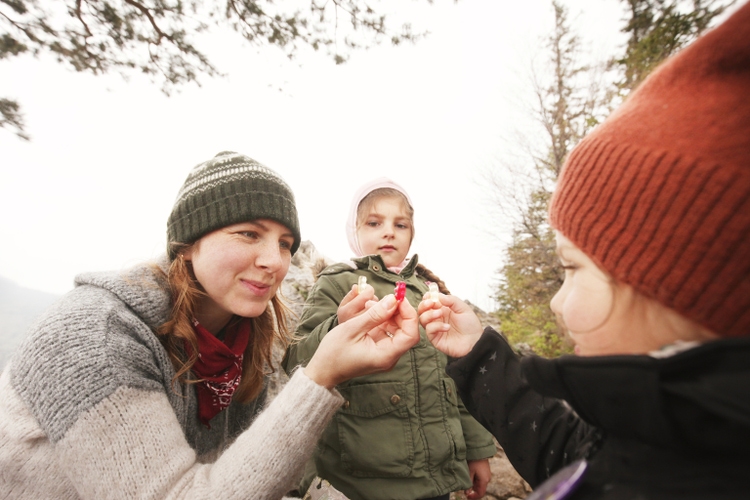 MOther with daughters having fun on trip eating gummy bears