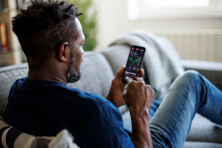 Man checking stock and cryptocurrency market on smart phone