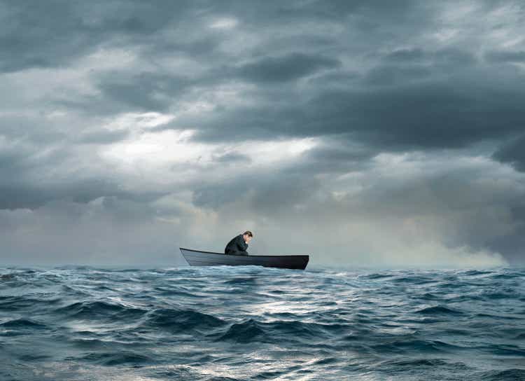 Dejected Man Sitting In Sinking Row Boat