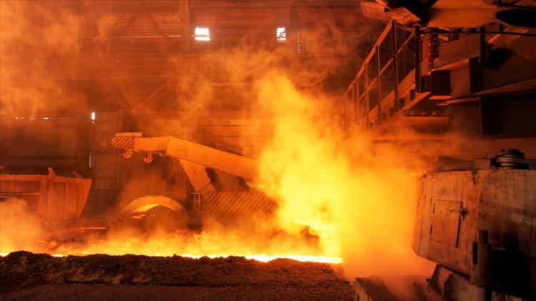 Hot steel being poured to the chute at the steel plant, heavy industry concept. Stock footage. Molten steel production in electric furnaces
