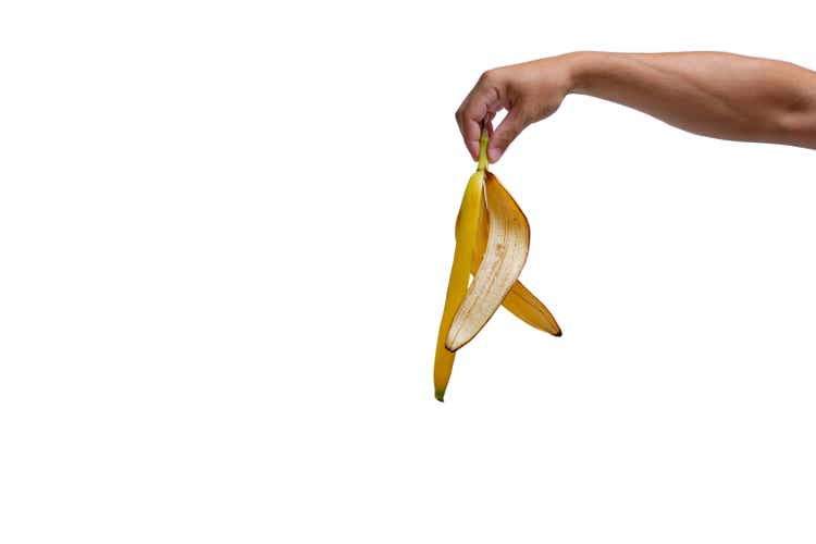 Banana peel in hand on white background, isolate.