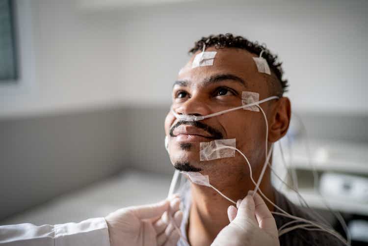 Doctor or nurse preparing patient for polysomnography (sleep study)