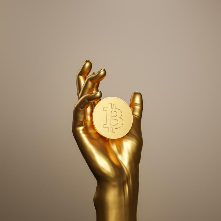 golden hand holding a bitcoin