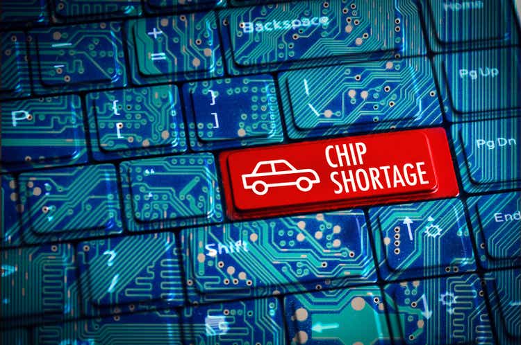 Chip Shortage or semiconductor automotive crisis concept with computer keyboard and motherboard circuits