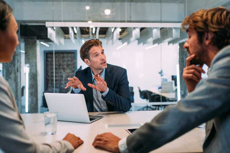 Group of business persons talking in the office.