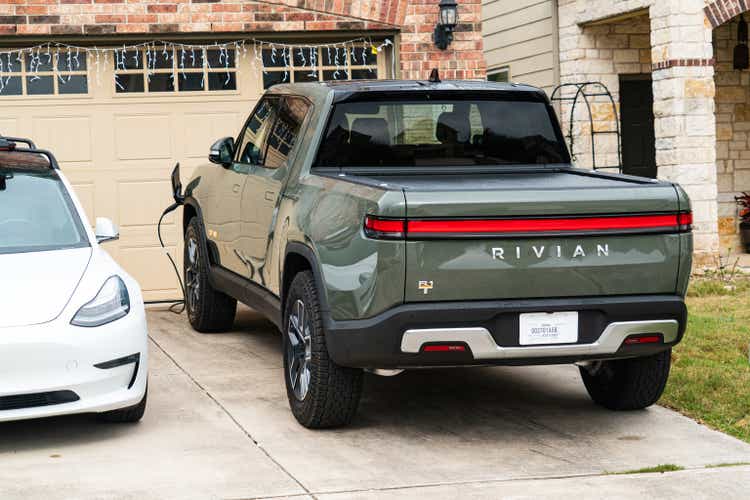 Rivian R1T Electric Pick Up Truck and a Tesla Model 3 parked in front of Home