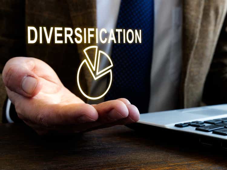 Businessman holds sign diversification as part of risk management.