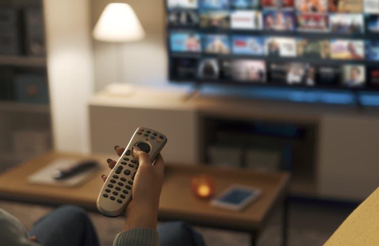 Young woman watching video on demand on her TV