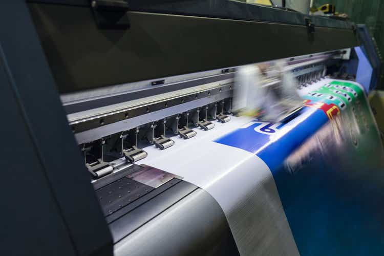 Large format inkjet printer working on vinyl paper in workplace